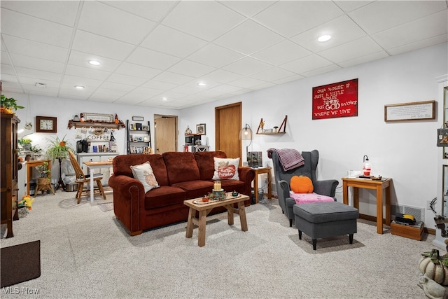 living room featuring a paneled ceiling and light carpet