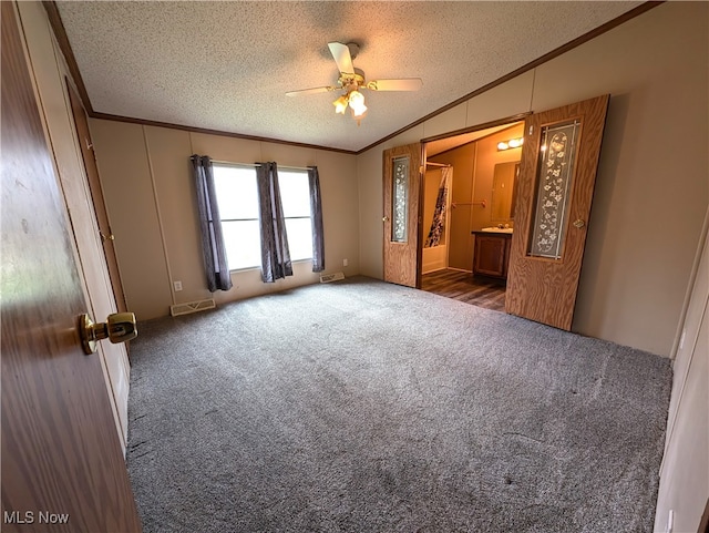 carpeted empty room featuring ceiling fan, a textured ceiling, lofted ceiling, and ornamental molding