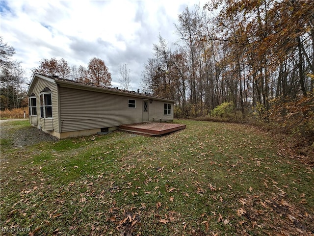 rear view of house featuring a wooden deck and a yard