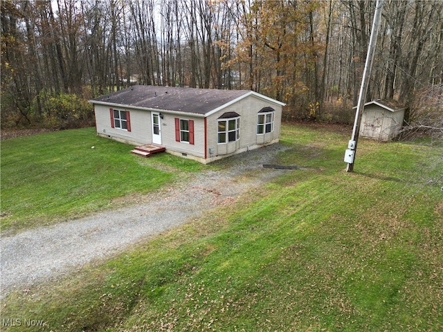 view of front facade featuring a front lawn and a storage unit