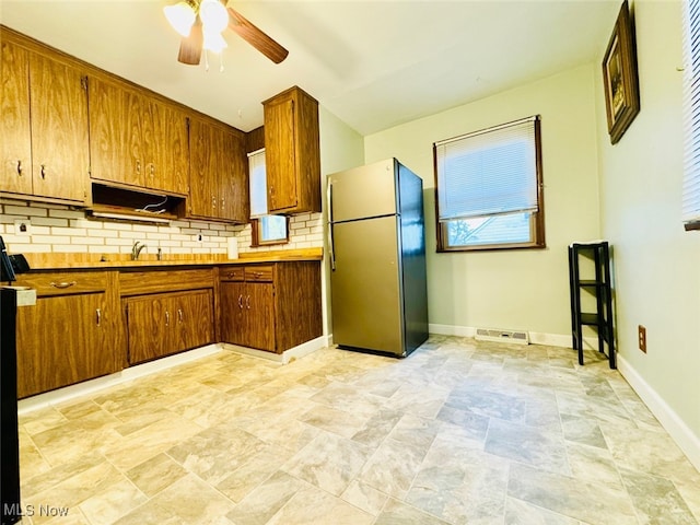 kitchen with ceiling fan, stainless steel refrigerator, and tasteful backsplash