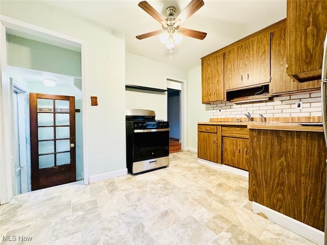 kitchen with tasteful backsplash, range, and ceiling fan