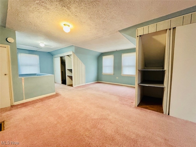 bonus room with carpet and a textured ceiling