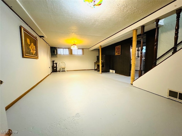 basement featuring washer / dryer and a textured ceiling