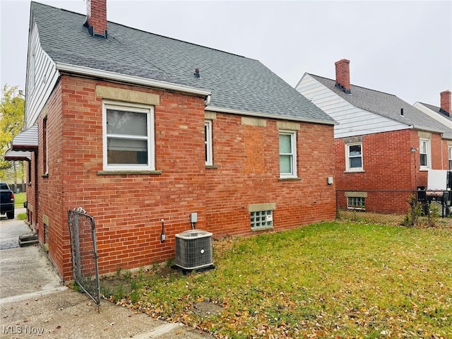 back of house with central AC and a yard