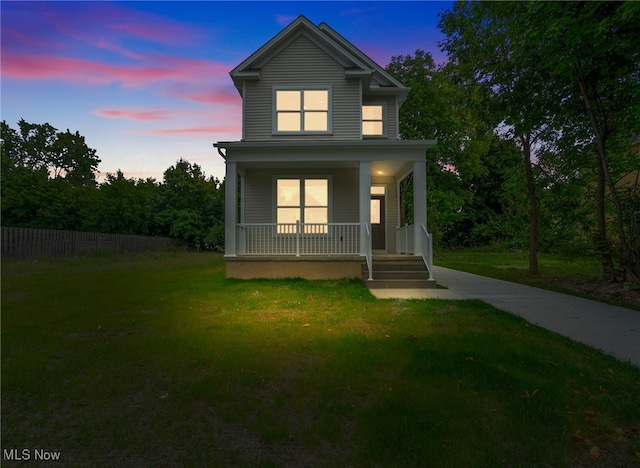 view of front facade featuring covered porch and a yard