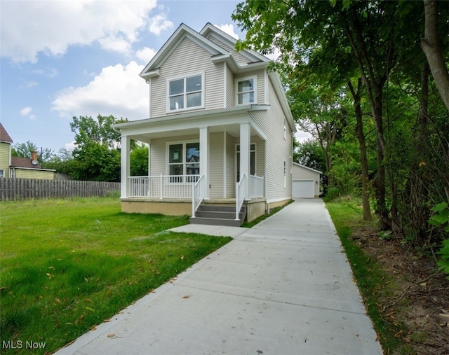 view of front of house with an outbuilding, a garage, covered porch, and a front lawn