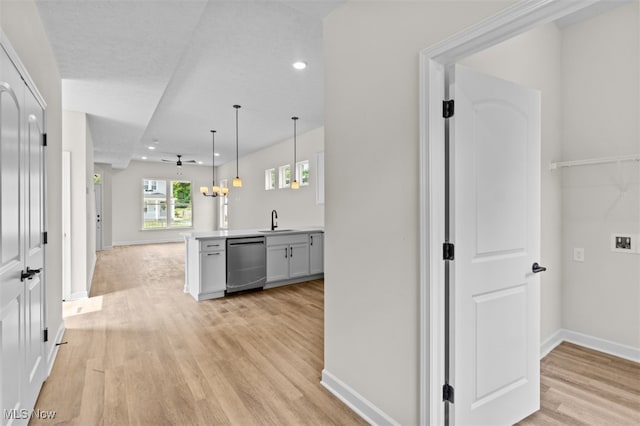 hall featuring light wood-type flooring, sink, and a chandelier