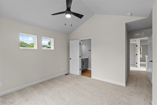 unfurnished bedroom featuring ensuite bathroom, ceiling fan, light carpet, and lofted ceiling