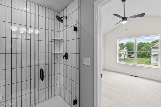 bathroom featuring vaulted ceiling and a shower with door