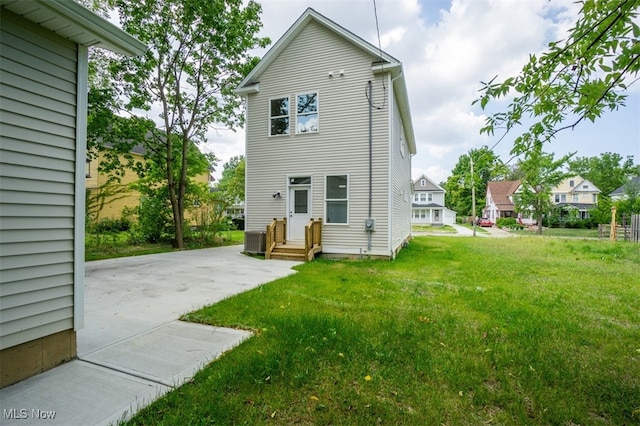 back of house featuring a lawn and central AC