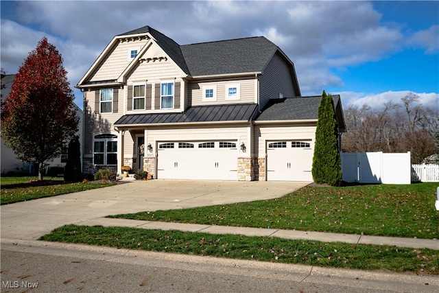 craftsman inspired home featuring a garage and a front lawn