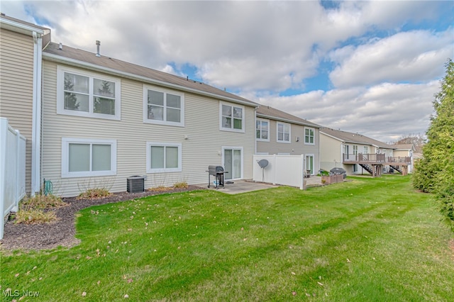 rear view of house featuring central AC unit, a lawn, a wooden deck, and a patio area