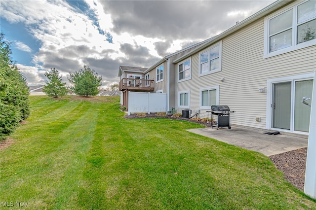 rear view of house featuring central air condition unit, a yard, and a patio