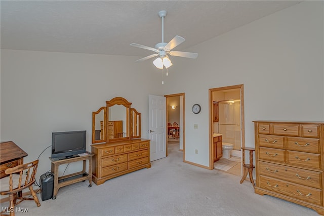 bedroom featuring ceiling fan, ensuite bath, high vaulted ceiling, and light colored carpet