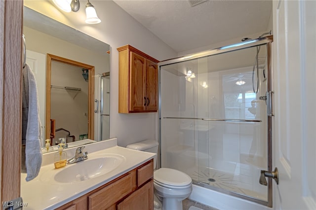 bathroom featuring vanity, a textured ceiling, toilet, and an enclosed shower