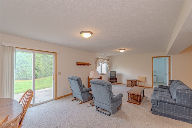 carpeted living room featuring a wealth of natural light and a textured ceiling