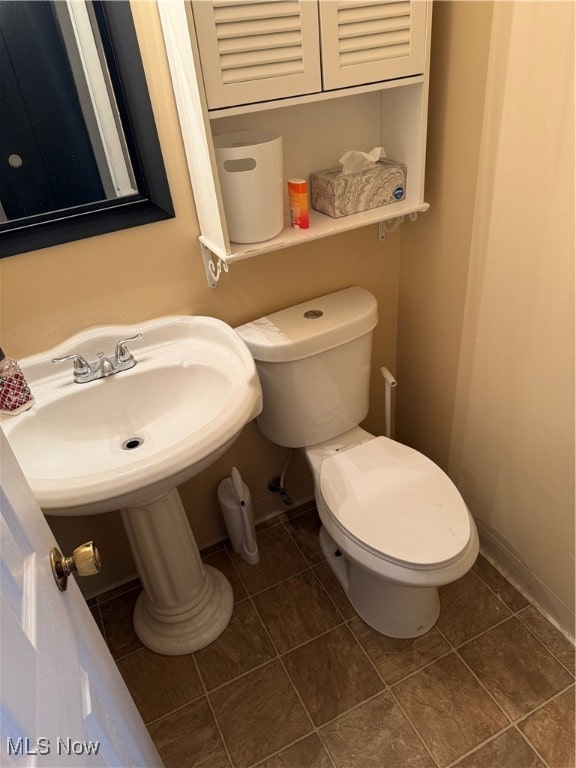 bathroom with toilet and tile patterned flooring