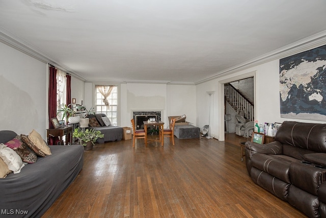 living room with dark hardwood / wood-style flooring, crown molding, and a fireplace