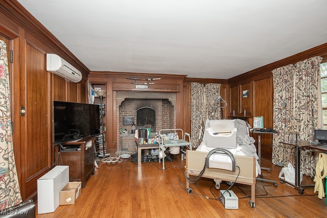 living room with light wood-type flooring, a wall unit AC, wood walls, and crown molding