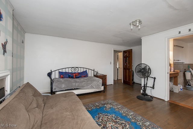 bedroom featuring connected bathroom and dark hardwood / wood-style flooring