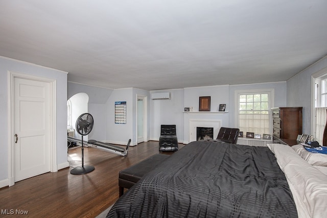 bedroom with an AC wall unit and dark hardwood / wood-style floors