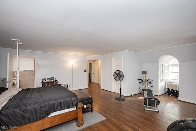 bedroom with an AC wall unit, lofted ceiling, and dark hardwood / wood-style floors