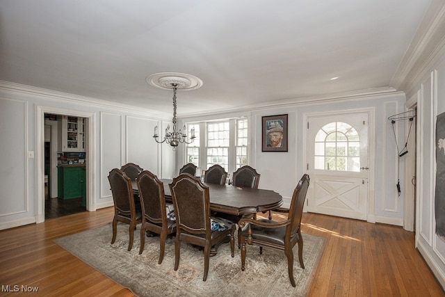 dining room featuring dark hardwood / wood-style flooring, an inviting chandelier, and ornamental molding