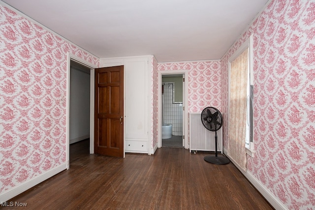 unfurnished bedroom with dark hardwood / wood-style floors and ensuite bathroom