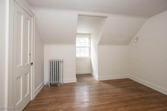 bonus room featuring radiator heating unit, lofted ceiling, and dark hardwood / wood-style floors