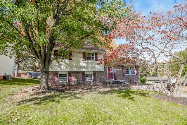 tri-level home with central AC unit and a front lawn