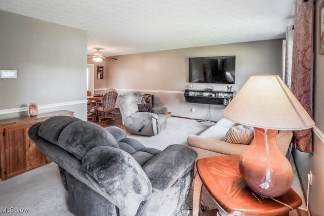 living room with a textured ceiling and ceiling fan