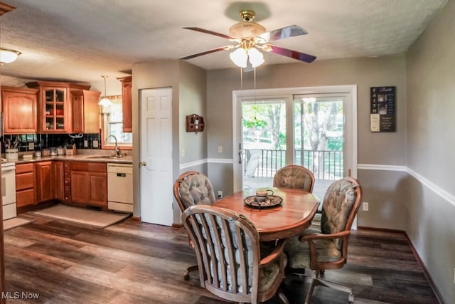 dining room with a textured ceiling, dark hardwood / wood-style flooring, sink, and ceiling fan