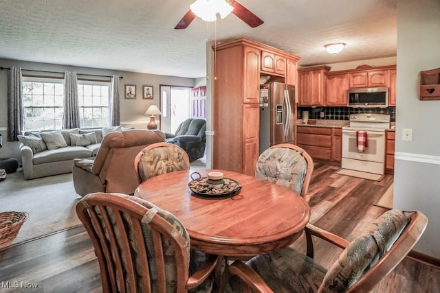 dining room featuring dark hardwood / wood-style flooring, a textured ceiling, and ceiling fan