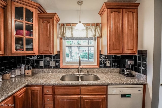 kitchen with dishwasher, decorative backsplash, dark stone counters, and sink