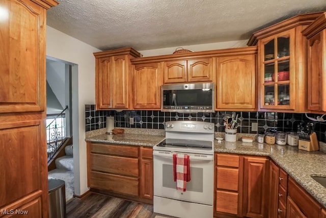 kitchen with white range with electric stovetop, light stone counters, a textured ceiling, dark wood-type flooring, and decorative backsplash