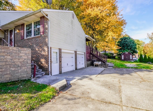 view of home's exterior with a garage and a storage unit