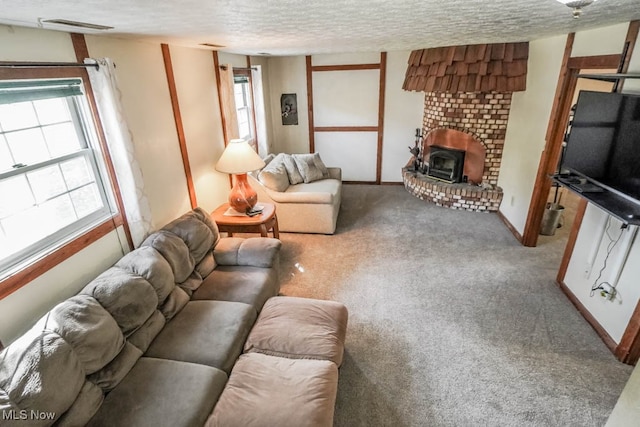 living room with a wood stove, carpet floors, and a textured ceiling