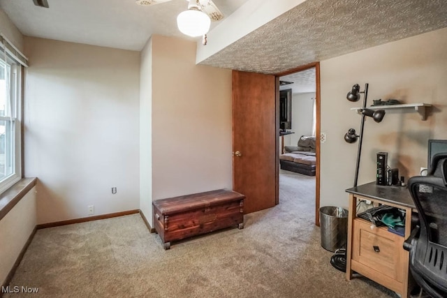 interior space featuring ceiling fan and light carpet