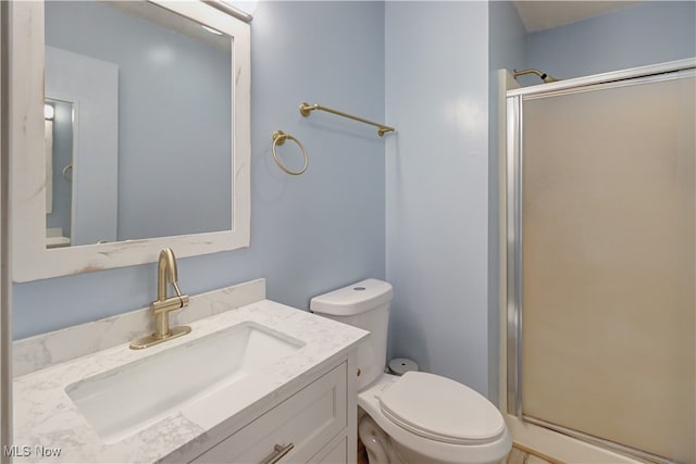 bathroom with vanity, toilet, and an enclosed shower