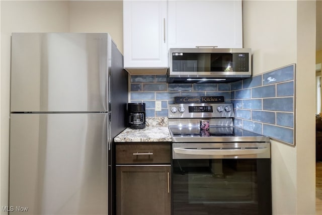 kitchen featuring tasteful backsplash, white cabinets, and stainless steel appliances