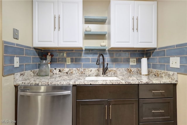 kitchen with dishwasher, white cabinets, sink, and light stone countertops