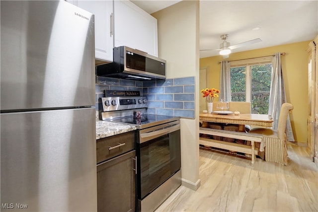 kitchen featuring stainless steel appliances, white cabinetry, dark brown cabinets, decorative backsplash, and light hardwood / wood-style flooring