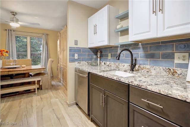 kitchen with dishwasher, white cabinetry, sink, and light stone counters