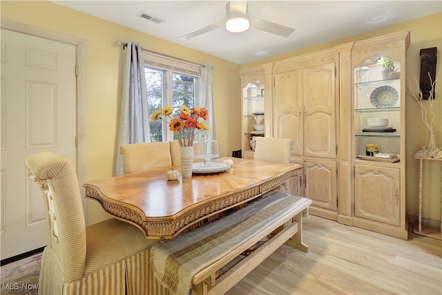 dining space with light hardwood / wood-style floors and ceiling fan