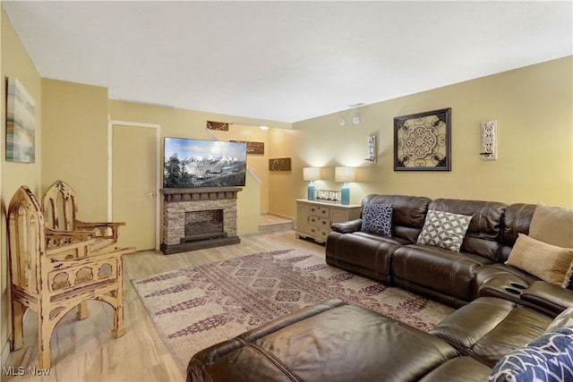 living room with a fireplace and light wood-type flooring