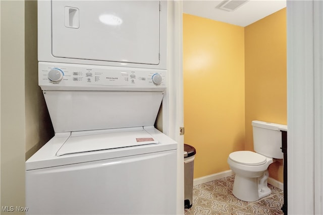 clothes washing area with stacked washer and clothes dryer and light tile patterned floors