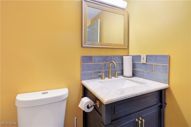 bathroom featuring toilet, tasteful backsplash, and vanity