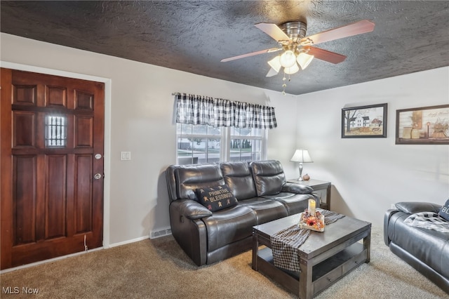 carpeted living room featuring ceiling fan and a textured ceiling