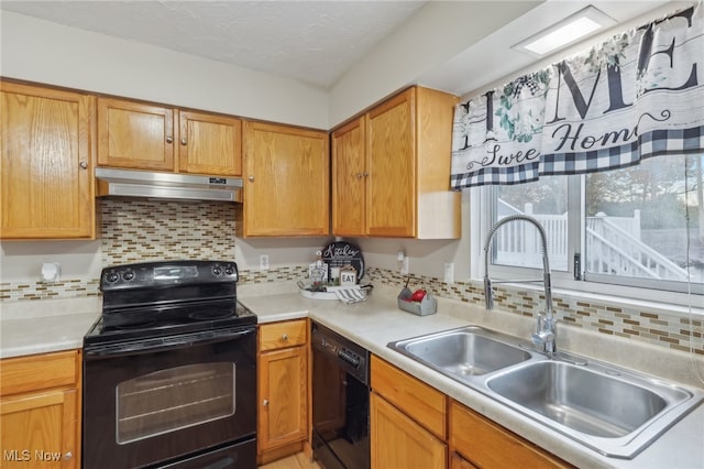 kitchen featuring black appliances, tasteful backsplash, and sink